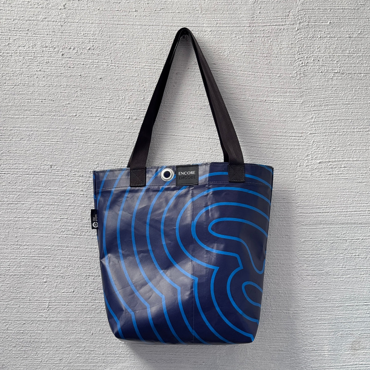 Tote bag with blue wave pattern on a gray textured background